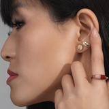 Mad Fine mismatched 14k gold stud earrings inspired by prescription pills, one oval with a line, the other round with "832" engraving.